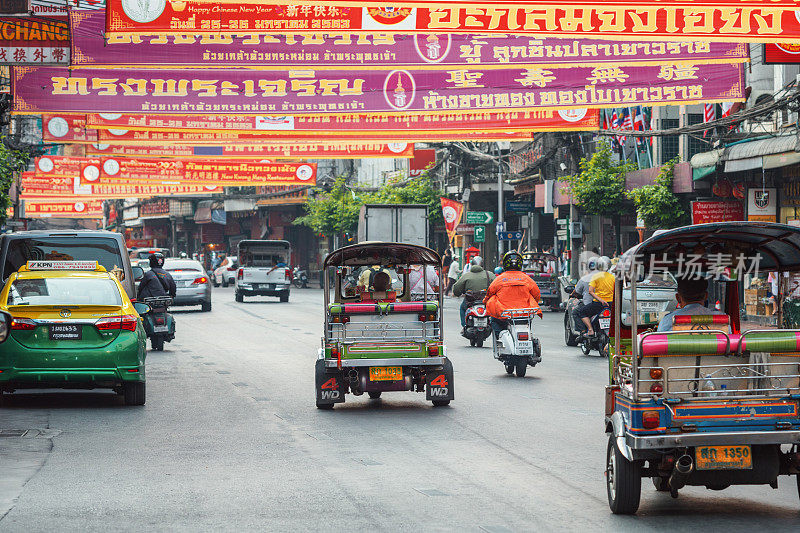 10/01/2020曼谷,泰国。“嘟嘟”(机动三轮车)在中国城的街道上迅速地把乘客带到这个地方。传统的人力车比汽车出租车便宜